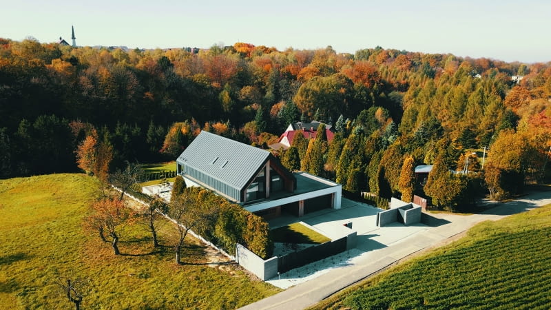 Dom otacza zieleń  – zarówno ta  „własna″, jak i znajdująca się  poza terenem  posesji.  Właściciele zastali  na działce  m.in. kilkumetrowe  tuje,których część  udało się ocalić.  Stanowiły one znak firmowy całej nieruchomości,  zapewniając jej  pewien stopień  prywatności