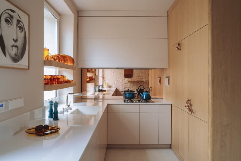 Ciemną kuchnię od strony północnej rozjaśnił jasny odcień herbacianego różu oraz dodatki w ciepłych kolorach