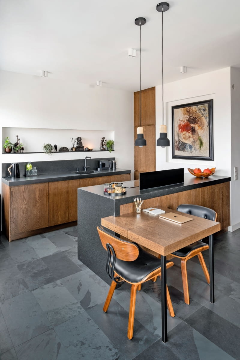 Na co dzień Marta i Michał korzystają z niewielkiego stołu. Na potrzeby większych imprez mebel można rozłożyć do trzech metrów długości. Stolarz wykonał blat stołu z tego samego forniru co szafki kuchenne. Zawisły nad nim dwie ładne, zgrabne lampki z betonu i drewna marki Hübsch.