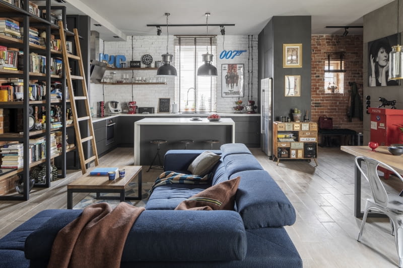 W całym mieszkaniu króluje nieco surowa, ale swobodna stylistyka. Lampy, półki, stołki, krzesła, ściany przypominają wyglądem wyposażenie fabrycznej hali. Na tym tle niezwykle luksusowo prezentuje się sofa.