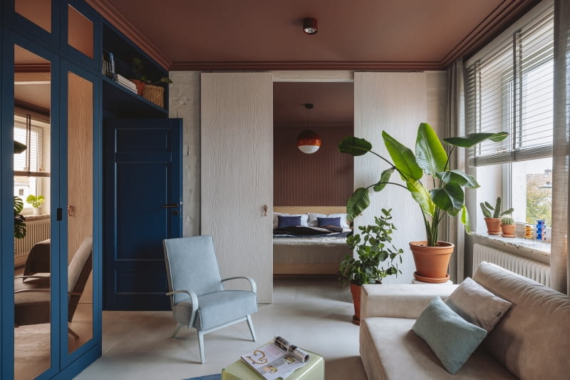 W salonie i sypialni terakotowy brąz pokrywa sufity i jedną ze ścian. Pięknie komponuje się z nim granat.