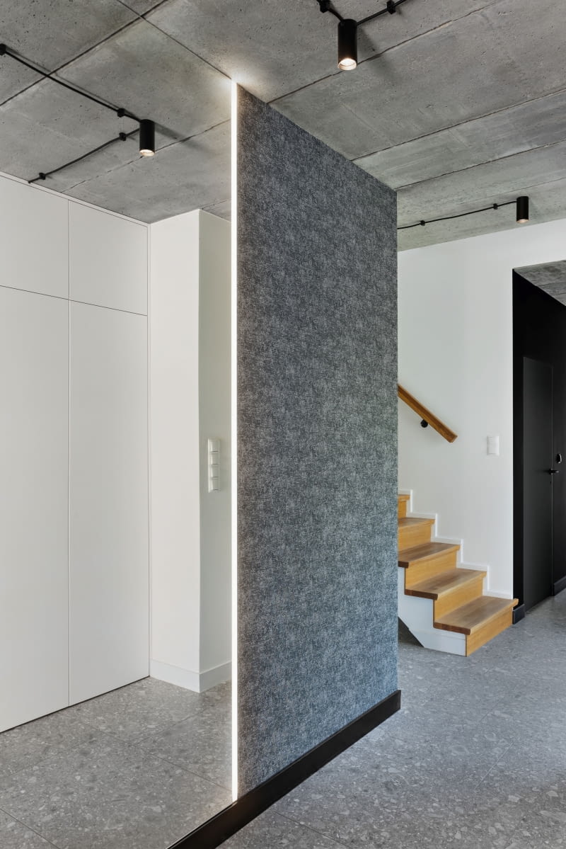 Kompozycję betonowych, kamiennych i białych powierzchni w strefie wejścia do domu doskonale dopełnia lustro na pełną wysokość. Optycznie powiększa nieduże pomieszczenie i jest niezastąpione podczas przeglądania się przed wyjściem. Fragment jednej ze ścian wykończono szarą tapetą, która wizualnie ociepla wnętrze. Kompozycję betonowych, kamiennych i białych powierzchni w strefie wejścia do domu doskonale dopełnia lustro na pełną wysokość. Optycznie powiększa nieduże pomieszczenie i jest niezastąpione podczas przeglądania się przed wyjściem. Fragment jednej ze ścian wykończono szarą tapetą, która wizualnie ociepla wnętrze.