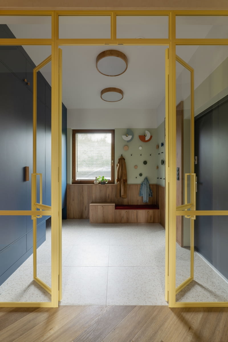 Niemały, o powierzchni 8,6 m2, wygodny do zmiany ubrań i obuwia przedsionek pomieścił wysoką do sufitu, ciemnoniebieską szafę na różne elementy garderoby, a także specjalnie zaprojektowane miejsce do siedzenia.