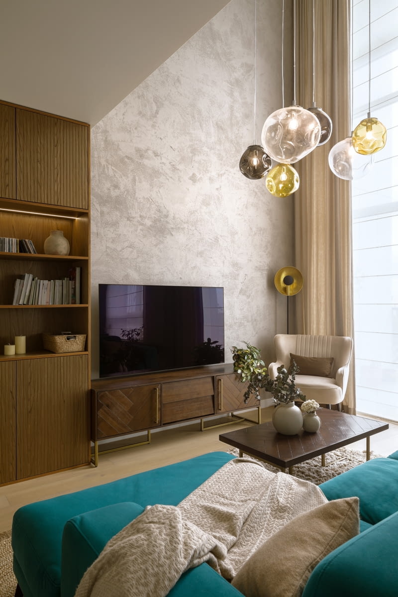 Widoczny z dwóch poziomów apartamentu kącik wypoczynkowy urządzono przy dwupoziomowym oknie. Otwartą, dwukondygnacyjną przestrzeń zaaranżowano tak, aby nie wydawała się pusta. Główną ścianę zdobi dekoracyjny tynk, okno można zasłonić sterowanymi automatycznie roletami rzymskimi i zasłonami, a kompozycję salonowych mebli zamyka od góry grupa szklanych lamp Avia L marki Kaspa z ciekawą powierzchnią ukształtowaną wgnieceniami. Widoczny z dwóch poziomów apartamentu kącik wypoczynkowy urządzono przy dwupoziomowym oknie. Otwartą, dwukondygnacyjną przestrzeń zaaranżowano tak, aby nie wydawała się pusta. Główną ścianę zdobi dekoracyjny tynk, okno można zasłonić sterowanymi automatycznie roletami rzymskimi i zasłonami, a kompozycję salonowych mebli zamyka od góry grupa szklanych lamp Avia L marki Kaspa z ciekawą powierzchnią ukształtowaną wgnieceniami.