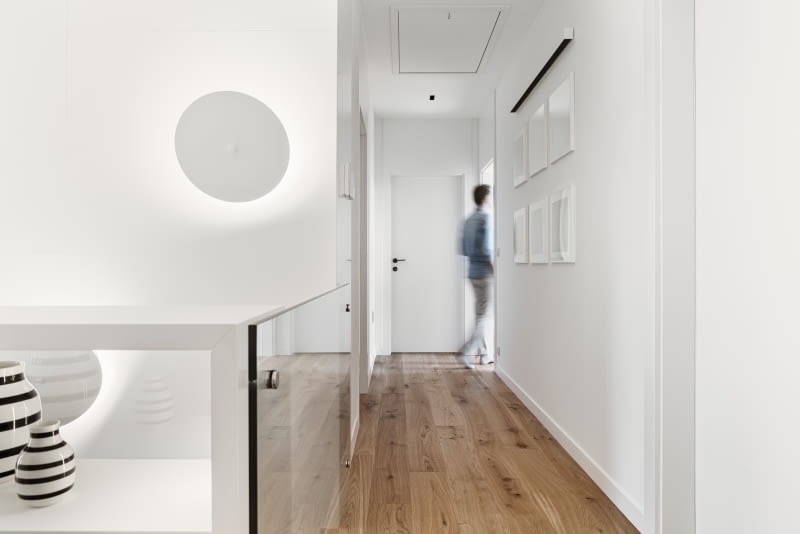 W kolorze bieli dobrano również bardzo proste kinkiety Ra Mini marki Chors. Można je zamówić w różnych rozmiarach i stosować pojedynczo lub w grupie. Talerze rozpraszające światło są ruchome, dzięki czemu zmiana ich ustawienia wpływa na kierunek padania światła.