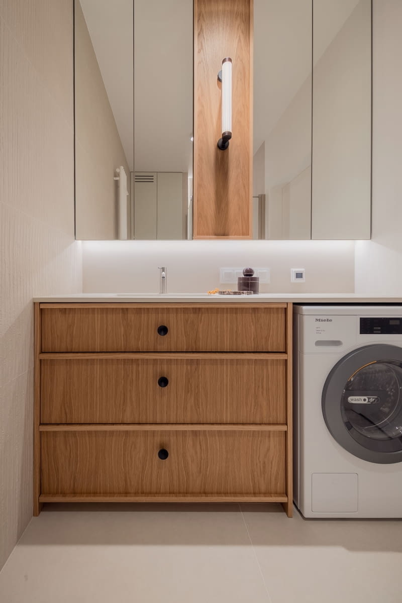 Projekt dewelopera zakładał umieszczenie umywalki i pralki na wprost wejścia. Architektka przeniosła je na boczną ścianę, dzięki czemu pomieszczenie stało się bardziej przestronne, a korzystanie z niego – wygodniejsze i bardziej intuicyjne.