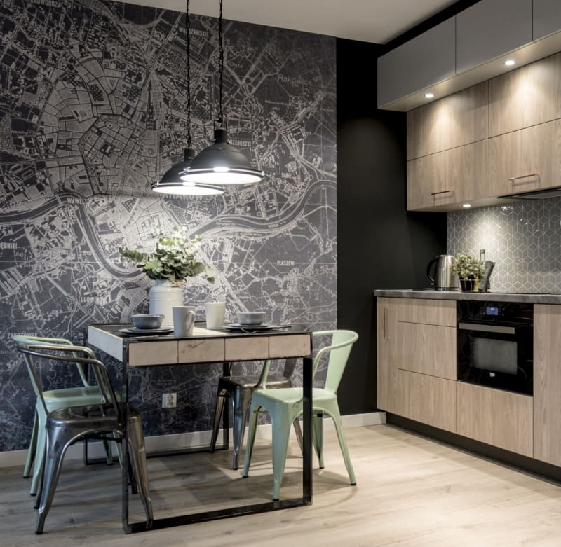 Grafitowo-biała tapeta z nadrukiem planu miasta podkreśla wystrój wnętrza inspirowanego stylem loftowym. Idealnie komponuje się z szarością, betonem, czarną stalą i kolorem naturalnego drewna.