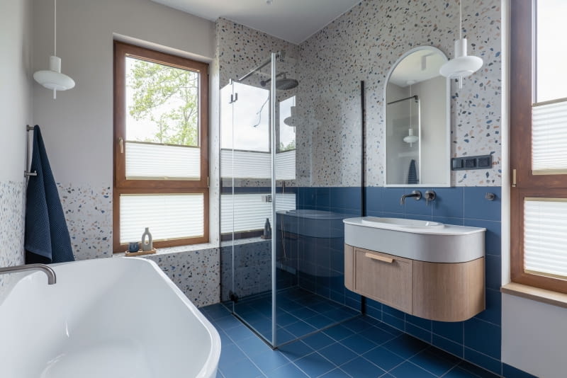 W łazience dzieci radosny klimat tworzy kolorowe lastryko od Pamesa Ceramica.  Jego wyrazisty wzór równoważą ciemnoniebieskie, kwadratowe kafle Equipe.