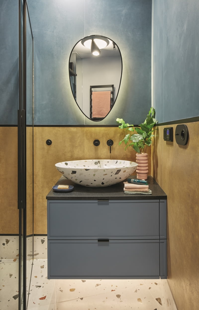 Zaczęło się od rudych płytek, które miały nawiązywać do koloru kanapy w salonie. Drugie płytki miały po prostu pięknie komponować się z rudymi, więc dopasowano je w kolorze niebieskim. Obydwie serie są sygnowane przez Marcina Tyszkę. Poważne zestawienie kolorystyczne ożywia barwne lastryko. Wisienką na torcie są czarne detale: blat i uchwyty meblowe szafki, listwy ścienne, profile kabiny prysznicowej, rama lustra, baterie i gniazdka. Wszystkie płytki pochodzą z salonu Max Fliz.