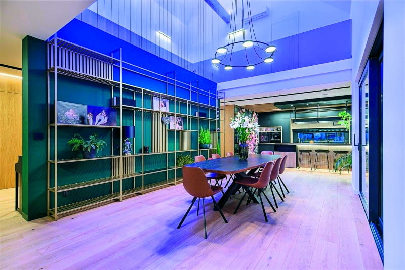 Otwarcie jadalni na górną kondygnację, aż po dach, pozwoliło wykreować niezwykłą przestrzeń, trochę w stylu sci-fi, trochę „sakralną"  (żyrandol nawiązujący m.in. do starych świątyń), podkreśloną przez intrygujący loftowy regał, zaprojektowany osobiście przez pana Pawła