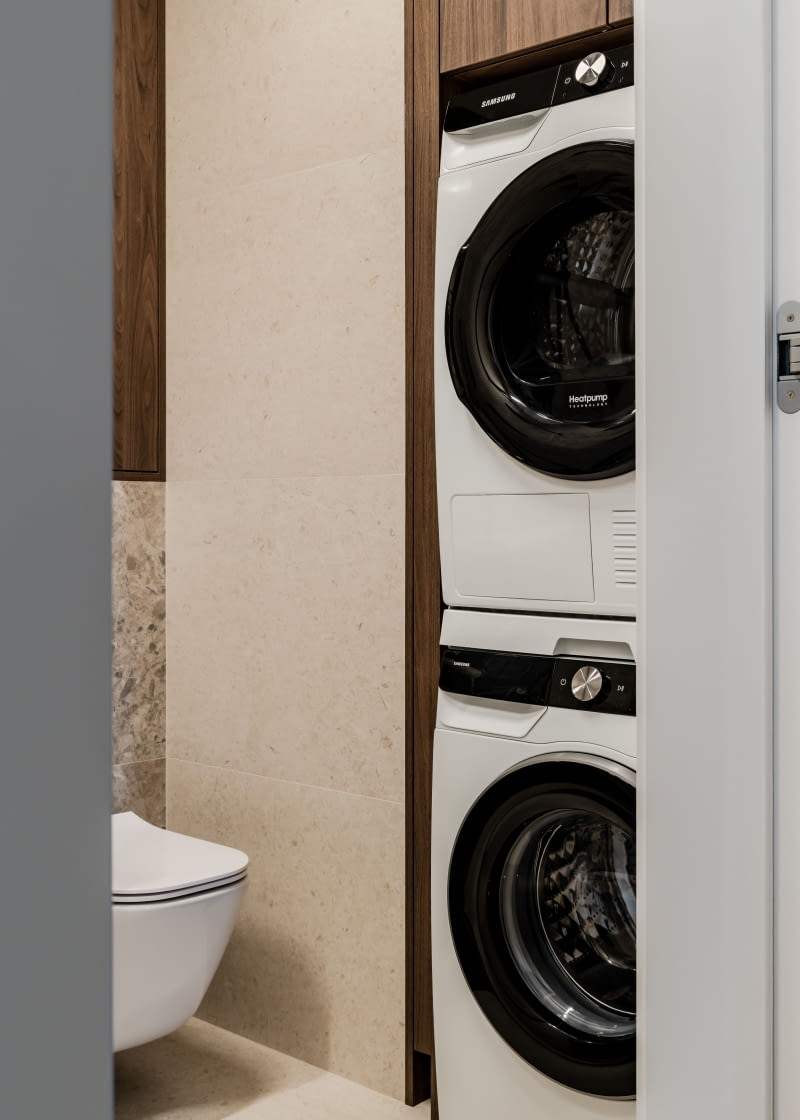 W łazience znalazło się też miejsce na wysoką szafkę, w której znalazła się pralka i suszarka.