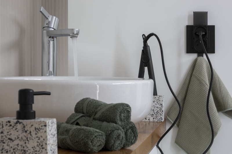 Podwójna, składana klapka gniazda chroni je przed zachlapaniem, co pozwala na bezpieczny montaż w łazience Osprzęt elektroinstalacyjny