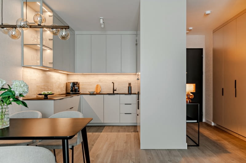 Po zapaleniu delikatne podświetlenie zabudowy kuchennej tworzy przyjemną atmosferę podczas odpoczynku w salonie otwartym na kuchnię.