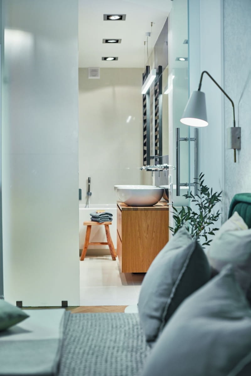 Łazienkę rodziców od sypialni oddzielają szklane, mleczne drzwi. Jest to kolejny element, który został przejęty po poprzednich właścicielach. Dobrze komponuje się z nową, przyjętą kolorystyką i dobranymi materiałami wykończeniowymi. Przez mleczne szkło wpada do środka łazienki światło z sypialni.