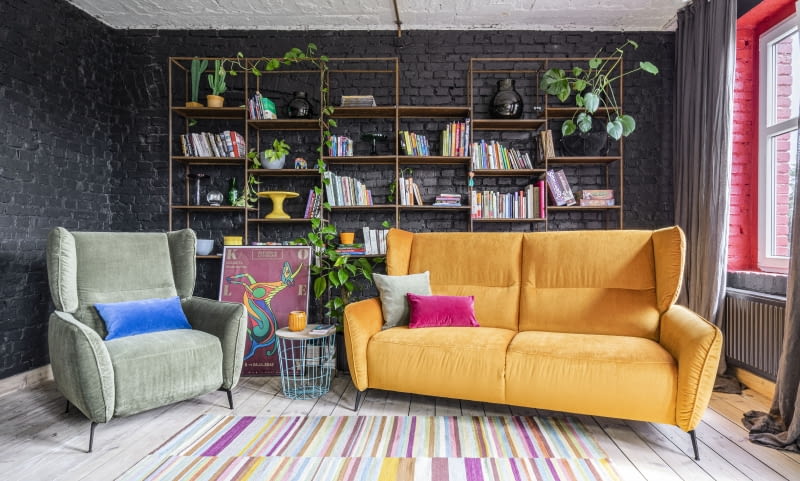 Zieleń ślicznie prezentuje się na tle czerni. Dopełnieniem aranżacji będą tapicerowane meble w żywych kolorach. urządzamy salon aranżacja salonu wnętrza