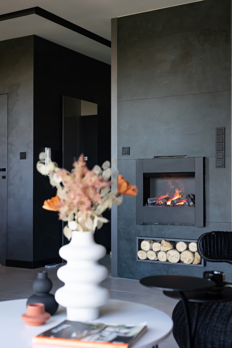 Kominek na parę wodną Dimplex z efektem płomieni 3D i imitacją żarzących się polan wygląda bardzo autentycznie. Ożywia przestrzeń salonu, a ciepły kolor ognia koresponduje z miedzianymi akcentami.