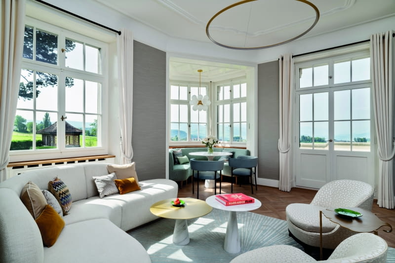 Przestronny główny salon jest wyposażony w stylowe, jasne meble i oferuje zapierający dech w piersiach widok na okolicę.