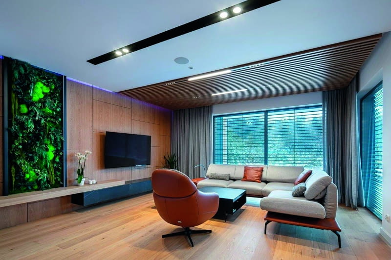 Salon z obszernym widokiem na ogród to  zarówno miejsce przeznaczone na spotkania  czy dyskusje toczone w nieformalnej  atmosferze, jak i przestrzeń pokazów  filmowo-telewizyjnych. Wszystko  w przyjaznym klimacie drewnianych  materiałów, z efektownymi  lamelkami u góry