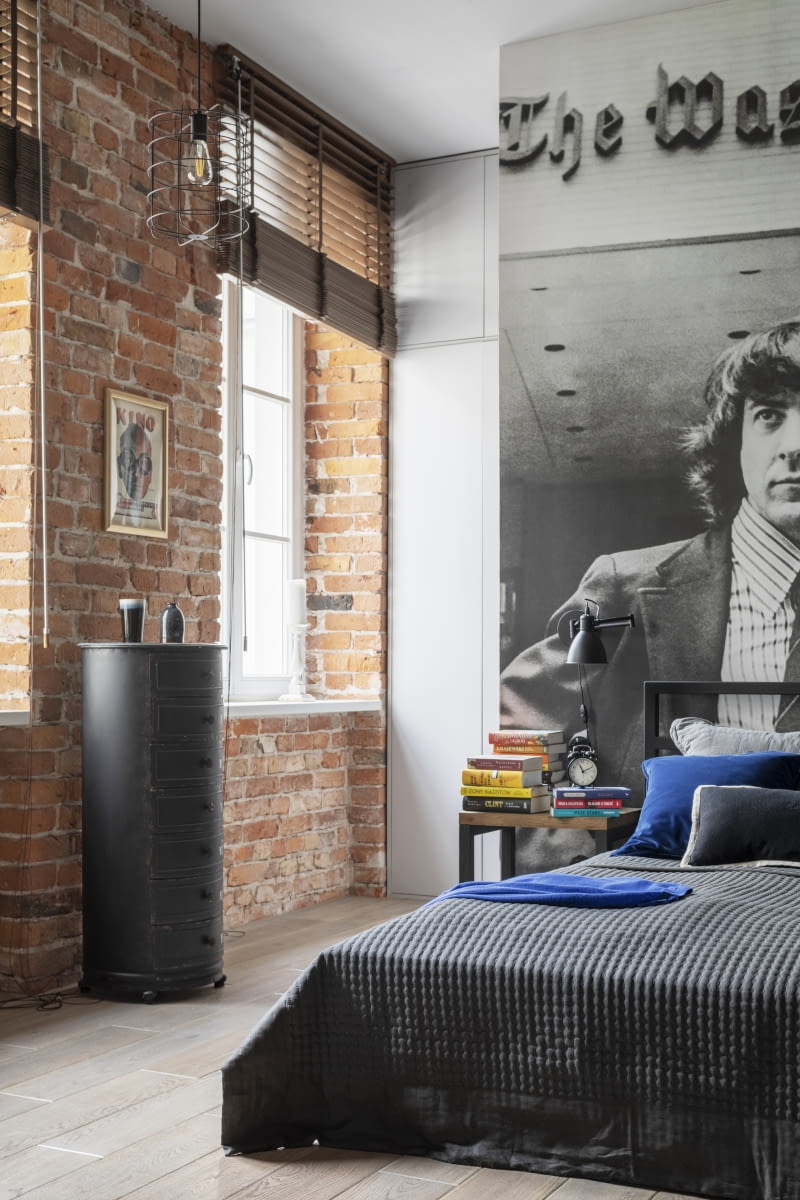 Za „filmowym” wezgłowiem łóżka kryją się dostępne z dwóch stron szafy na ubrania. Sprytnie schowane nie ingerują w otwartą przestrzeń mieszkania, a przy tym łatwo jest z nich korzystać.