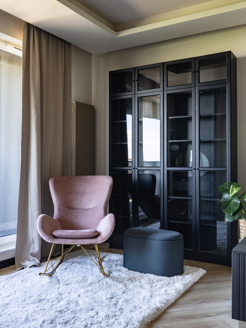 Aranżację sypialni, która sprzyja wyciszeniu i odpoczynkowi, kreują wprowadzone do przestrzeni ciepłe, neutralne beże i róż, połączone z odcieniami niebieskiego. Jasny błękit i granat to motyw kolorystyczny z tapety marki Walldecor, która zdobi ścianę z wejściem do garderoby. Dopasowano ją do zagłówka łóżka.