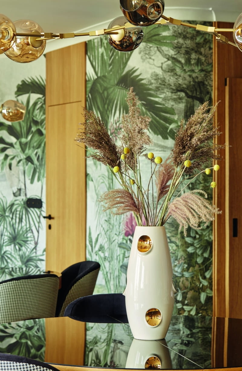 Dobrany przez architektkę i właścicielkę mieszkania wzór tapety odzwierciedla zamiłowanie rodziny do dalekich podróży. Stąd egzotyczne rośliny, łódki, pejzaże i piękno natury.