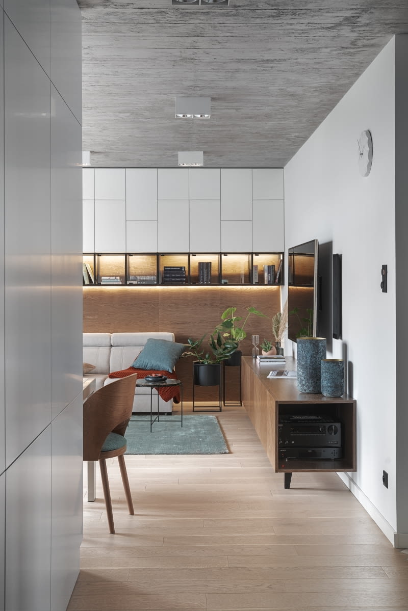 Prace nad projektem architekci podjęli w momencie, w którym deweloper otynkował już sufity. Zamiast więc skuwać gotową już zaprawę, aby odsłonić betonową płytę stropową, zdecydowano o wykończeniu sufitów tynkiem o strukturze betonu. Finalny efekt osiągnięto, stosując silikonowe formy do odbijania szalunku z desek. Ozdobny tynk rozwiązał też problem prowadzenia natynkowo instalacji elektrycznych na suficie, co byłoby konieczne przy surowej płycie stropowej, a do czego nie miał przekonania właściciel – Romuald. Prace nad projektem architekci podjęli w momencie, w którym deweloper otynkował już sufity. Zamiast więc skuwać gotową już zaprawę, aby odsłonić betonową płytę stropową, zdecydowano o wykończeniu sufitów tynkiem o strukturze betonu. Finalny efekt osiągnięto, stosując silikonowe formy do odbijania szalunku z desek. Ozdobny tynk rozwiązał też problem prowadzenia natynkowo instalacji elektrycznych na suficie, co byłoby konieczne przy surowej płycie stropowej, a do czego nie miał przekonania właściciel – Romuald.