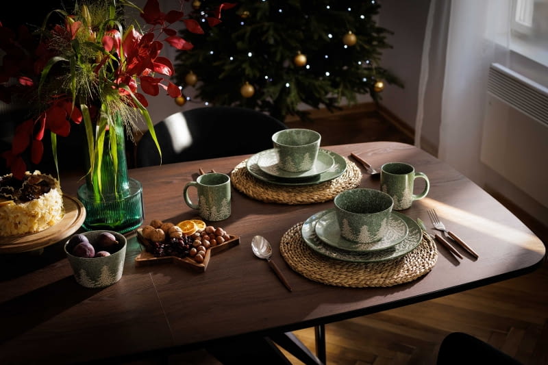 Zielona ceramika z motywem świerkowego lasu dobrze wygląda z naturalnymi materiałami, np. drewnem czy liśćmi trawy morskiej.