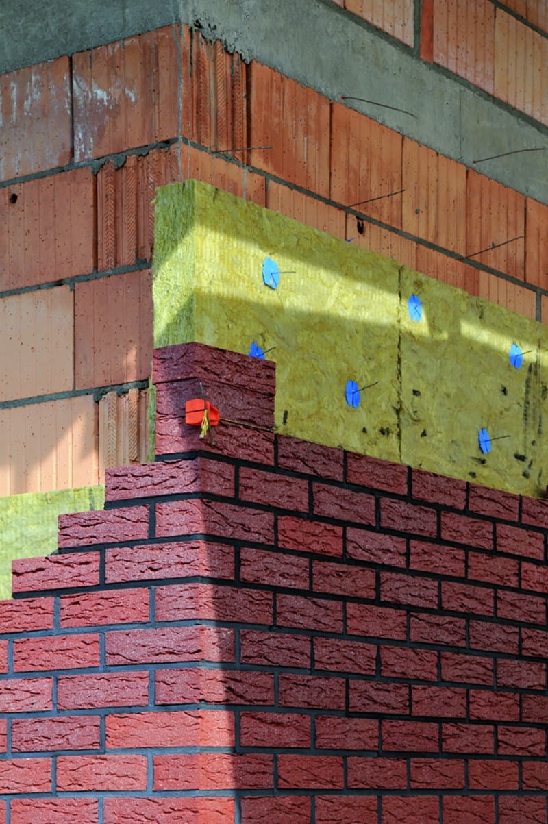 Warstwę nośną z elewacyjną łączy się kotwami, czyli odpowiednio wyprofilowanymi drutami, które wmurowuje się co kilka warstw ściany nośnej i okładziny zewnętrznej, przebijając nimi warstwę termoizolacji Warstwę nośną z elewacyjną łączy się kotwami, czyli odpowiednio wyprofilowanymi drutami, które wmurowuje się co kilka warstw ściany nośnej i okładziny zewnętrznej, przebijając nimi warstwę termoizolacji