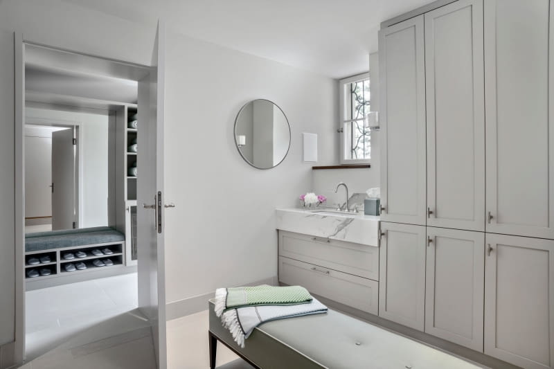 Strefa wellness na parterze: zastosowanie naturalnych materiałów, takich jak teksturowany wapień i drewno, nadaje pokojom spa uspokajającą atmosferę.