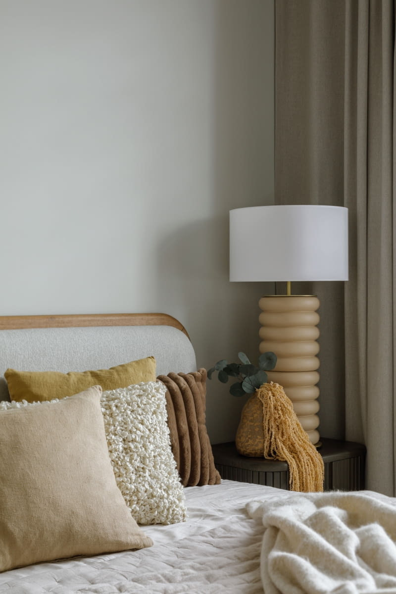 Ustawienie łóżka prostopadle do dłuższej ściany pozwoliło na umieszczenie po jego obydwu stronach nocnych szafek – pochodzą z tej samej kolekcji Mailen marki Kave Home co mebel RTV w salonie