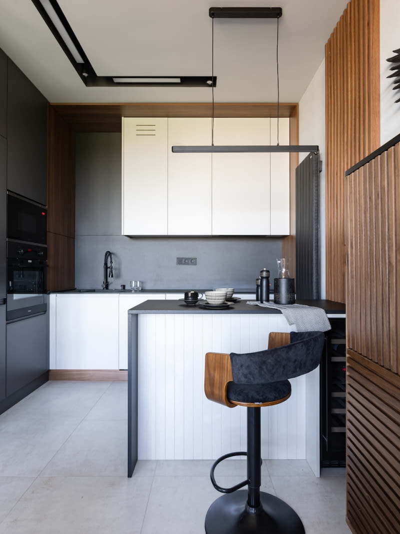 Jak podkreślają gospodarze, kuchnia, choć nieduża, jest bardzo wygodna w codziennym użytkowaniu. Zwłaszcza Barbara, która na co dzień gotuje dla siebie i Rafała docenia starannie przemyślane rozplanowanie sprzętów AGD oraz miejsc do przechowywania. Właściciele szczególnie cieszą się z pomysłu wkomponowania w zabudowę wyspy małej lodówki na wino, której zalet nie mieli wcześniej okazji sprawdzić osobiście.