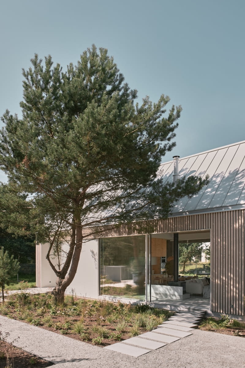 Drewno elewacji wnosi szlachetną fakturę oraz naturalną zmienność związaną z procesem starzenia, aluminiom natomiast buduje subtelną grę refleksów zależną od pory dnia i warunków atmosferycznych. Wzajemne oddziaływanie tych materiałów sprawia, że fasada pozostaje w ciągłym dialogu ze światłem i otoczeniem. Drewno elewacji wnosi szlachetną fakturę oraz naturalną zmienność związaną z procesem starzenia, aluminiom natomiast buduje subtelną grę refleksów zależną od pory dnia i warunków atmosferycznych. Wzajemne oddziaływanie tych materiałów sprawia, że fasada pozostaje w ciągłym dialogu ze światłem i otoczeniem.