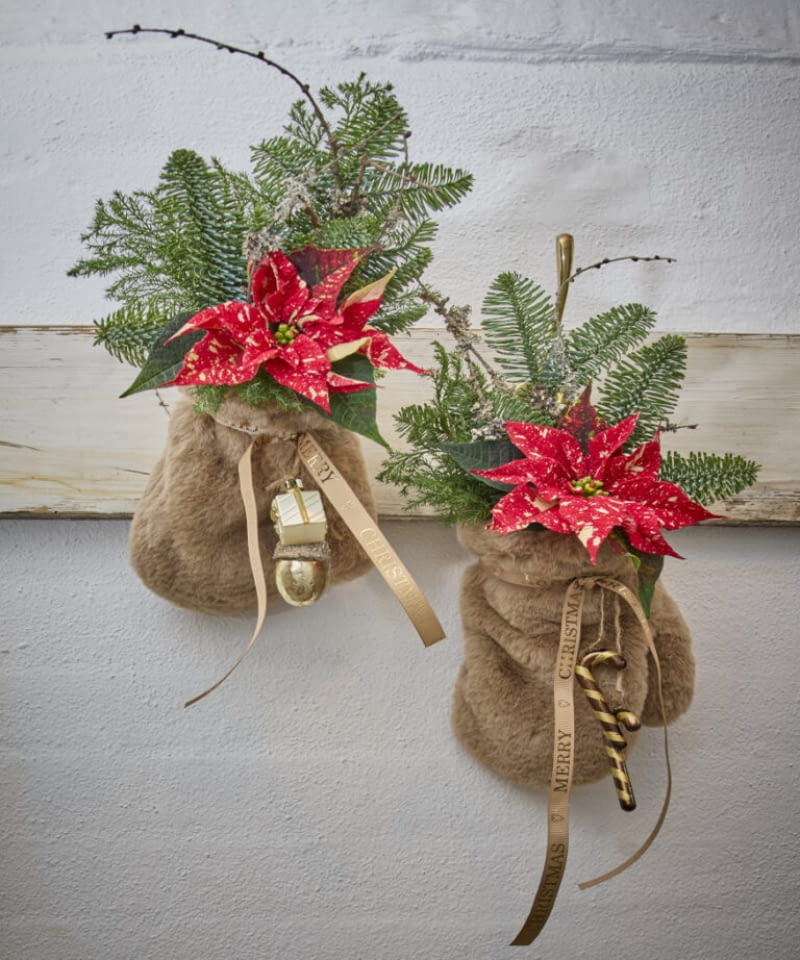 Ciekawym pomysłem są także miniaturowe poinsecje umieszczone w miękkich, futrzanych rękawiczkach zawieszonych na rustykalnym wieszaku.