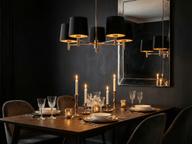 Nad stołem zawisła klasyczna lampa Ponte w eleganckim czarnym kolorze z zewnątrz i złotym w środku. Jej ciepłe światło wzmocnione zostało blaskiem świec.