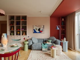 W tym mieszkaniu kolor nie jest dodatkiem, lecz pełnoprawnym bohaterem, który kreuje przestrzeń pełną emocji. Na zdjęciu niebieska sofa to model marki Optisofa, a stojąca niebieska lampa producenta Aldex. Na niebieskim stoliku ze sklepu Jotex wyeksponowano wazon Nana Malwiny Konopackiej. Honorowe miejsce nad sofą zajmuje obraz Agnieszki Pietrzykowskiej.