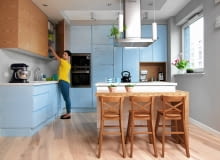 PRZECHOWYWANIE W KUCHNI. Wysoka zabudowa nie przytłacza wnętrza głównie dzięki jasnej kolorystyce. Błyszczące fronty szafek mają delikatny błękitny odcień, kojarzący się z wodą - wyspa z lakierowanej płyty MDF jest więc jak najbardziej na miejscu. Wisząca szafka fornirowana jesionem i blat wokół wyspy z tego drewna ożywiają wnętrze. W podwieszonym suficie zainstalowano halogeny, posłużył też do ukrycia instalacji okapu wyspowego. <BR /> Po lakierowanych frontach gospodyni pisze flamastrem do tablic zmywalnych, a do ścierania napisów używa zwykłej gąbki. OLYMPUS DIGITAL CAMERA