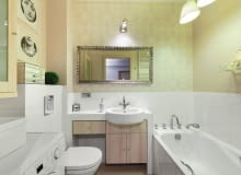 ŚCIANY mniej więcej do połowy wykończono białymi płytkami ceramicznymi; górną część pomalowano wodoodporną farbą w odcieniu beżu, a na ścianie z lustrem położono tapetę. Ponieważ nie udało się znaleźć szafki odpowiedniej wielkości, została zrobiona na wymiar. Podwieszono ją pod blatem z umywalką, wykonanym z płyty gipsowo-kartonowej obłożonej kafelkami.