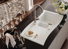 Nowoczesny zlewozmywak pretenduje do roli centrum dowodzenia przygotowywaniem posiłków. Dlatego poza dużymi komorami, które sprawdzają się przy zmywaniu naczyń, miewa wyposażenie dodatkowe. Mogą to być: mniejsza komora ze stalowym ociekaczem, automatyczny korek, czy deska do krojenia (położona nad komorą powiększy roboczą przestrzeń blatu). Zwykle im lepiej wyposażony zlew, tym droższy. Nie jest to jednak regułą, bo liczy się też materiał, z jakiego został wykonany, wzornictwo i marka. Na zdjęciu model New Wave. Półtorakomorowy z ociekaczem, nakładany na blat, ceramika z powłoką Ceramicplus, standardowe wyposażenie: korek automatyczny, wym. 980 x 510 mm, minimalna szerokość szafki - 60 cm. Cena 4654 zł. Villeroy&Boch zlewozmywaki