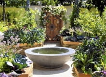 Aranżacje ogrodów. Chelsea Flower Show 2011. Stylowe drzwi oplecione pnącą różą i kamienna misa z wodą to piękne elementy dekoracyjne tego ogródka 25.05.2011 LONDYN CHELSEA FLOWER SHOW NA ZDJECIU OGROD POKAZOWY ALEJKA , SCIEZKA , OCZKO WODNE DLA CZASOPISMA FOT. ARKADIUSZ SCICHOCKI / AGENCJA GAZETA SLOWA KLUCZOWE: OGROD