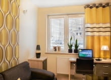 <B>Początkowo miała być w jednej, żółtej barwie. Jednak pomyłka krawcowej sprawiła, że materiał trzeba było połączyć z pasami uszytymi z innej tkaniny. Efekt okazał się bardzo korzystny, tym bardziej, że taka zasłona lepiej wpisała się w wystrój wnętrza.</B> <BR />Pani domu nie mogła uwierzyć, że pierwsza krawcowa jej nie zrozumiała i zamiast zgodnie z zamówieniem uszyć jedną zasłonę, przecięła materiał wzdłuż i oddała jej dwie wąskie. Zostały więc zszyte, ale nie wyglądało to dobrze. Dopiero w pracowni pani Magdy wymyślono, jak uratować efektowną tkaninę. Doszyto do niej inny materiał w kolorowe poziome pasy, które odwracają uwagę od szwu. Tak powstała wzorzysta dekoracja okienna, która nawiązuje do barw i motywów tapety na ścianie. <B>Początkowo miała być w jednej, żółtej barwie. Jednak pomyłka krawcowej sprawiła, że materiał trzeba było połączyć z pasami uszytymi z innej tkaniny. Efekt okazał się bardzo korzystny, tym bardziej, że taka zasłona lepiej wpisała się w wystrój wnętrza.</B> <BR />Pani domu nie mogła uwierzyć, że pierwsza krawcowa jej nie zrozumiała i zamiast zgodnie z zamówieniem uszyć jedną zasłonę, przecięła materiał wzdłuż i oddała jej dwie wąskie. Zostały więc zszyte, ale nie wyglądało to dobrze. Dopiero w pracowni pani Magdy wymyślono, jak uratować efektowną tkaninę. Doszyto do niej inny materiał w kolorowe poziome pasy, które odwracają uwagę od szwu. Tak powstała wzorzysta dekoracja okienna, która nawiązuje do barw i motywów tapety na ścianie.