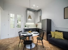 Ozdobami salonu są krzesła w stylu vintage i wisząca pozłacana lampa