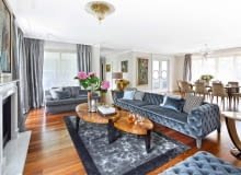 Salon połączony z jadalnią tworzy imponującą strefę dzienną. Od kuchni oddzielają go drzwi z dekoracyjnym motywem koła. Oświetlenie La Murrina i Baccarat. Podłoga (w całym apartamencie) z naturalnego orzecha amerykańskiego (Kahrs).