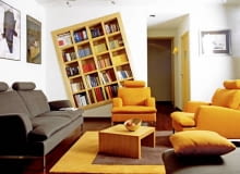 Na przekór. Jak mówią gospodarze tego mieszkania, pokój dzienny, w którym znajduje się domowy księgozbiór, miał być zaaranżowany "nie do końca na serio, z lekką nutką designerskiej przekory". Trzeba przyznać, że ten zamysł udało im się zrealizować w stu procentach. Niekonwencjonalny regał na książki - regularna, modułowa konstrukcja z drewna, wbudowana skosem w ścienną wnękę - może przyprawić o prawdziwy zawrót głowy! WNETRZA MEBLE