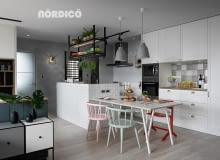 Pomysł na kuchnię skandynawską z wyspą obudowaną ścianką pokrytą prostymi, białymi płytkami ceramicznymi.