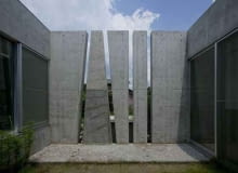 Slit House, czyli Dom Szczelina od EASTERN design office. Budynek otacza betonowy mur długości 105 metrów, w którym zamiast okien wyżłobiono 60 szczelin, tworzą one abstrakcyjny ornament ornament, japońska architektura, eastern design office, fasada, dom jednorodzinny