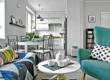 Mała kuchnia (ok. 5 m kw.) jest połączona z pokojem dziennym. Umowną granicę wyznacza stół, przy którym stoją krzesła ogrodowe z IKEA - mają ażurową konstrukcję, dzięki czemu wyglądają bardzo lekko. Poduszka na fotelu powstała w pracowni gospodyni, z niej pochodzi też tkanina, którą został obity stary puf. Kuchnia otwarta na salon, pokój dzienny