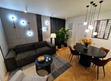 Ważne miejsca w pomieszczeniu podświetlają różnego rodzaju lampy. „Kamienną” ścianę zdobią czarne kinkiety od Nowodvorskiego. Przy kanapie stanęła biała lampa od 4concepts. Nad stołem wiszą kule marki Kaspa, a przy telewizorze lampy-tuby z Ramko. Ważne miejsca w pomieszczeniu podświetlają różnego rodzaju lampy. „Kamienną” ścianę zdobią czarne kinkiety od Nowodvorskiego. Przy kanapie stanęła biała lampa od 4concepts. Nad stołem wiszą kule marki Kaspa, a przy telewizorze lampy-tuby z Ramko.
