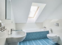 Widok na łazienkę ulokowaną na poddaszu pod połacią dachu i przeznaczoną do użytku przez najmłodszych członków rodziny łazienka, poddasze, łazienka na poddaszu