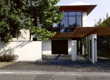 Widok na dom od strony ulicy. Za przeszklonymi ścianami na piętrze zaplanowano pracownię plastyczną. Drugi podobny szklany kubik od strony skarpy mieści jadalnię