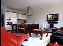 Żeby kolorystyka mieszkania nie była zbyt monotonna, dodano elementy w gorącym odcieniu czerwieni. Taką barwę ma nie tylko wygodny szezlong, ale także dodatki - ramki, naczynia, gazetownik. UWAGA PONOWNA PUBLIKACJA ZA ZGODA WLASCICIELI